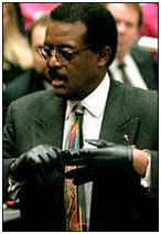 Johnny Cochran trying on glove in court